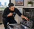 City Appliances technician inspecting a used 24-inch built-in dishwasher in a Sacramento kitchen before purchase.