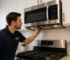 City Appliances technician inspecting an over-the-range microwave vent above a kitchen range in Citrus Heights